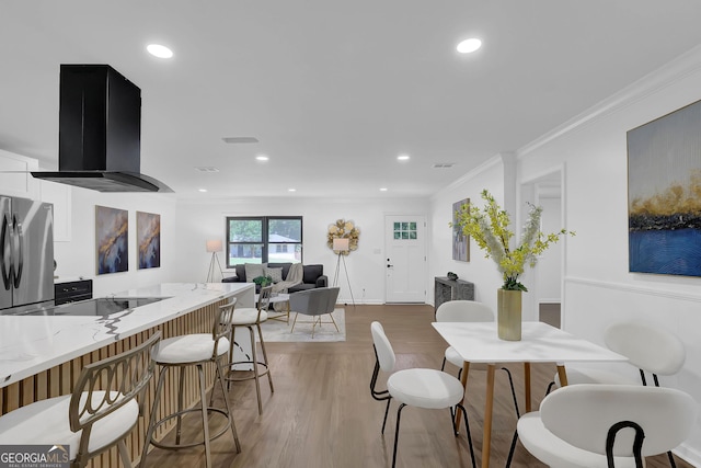 dining space with hardwood / wood-style floors and ornamental molding