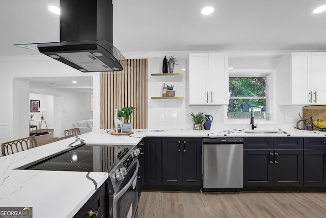 kitchen with light stone counters, white cabinets, appliances with stainless steel finishes, and island exhaust hood