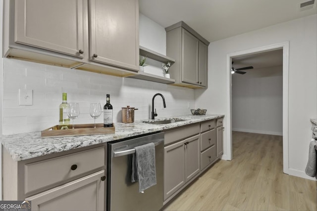 kitchen featuring dishwasher, gray cabinets, light hardwood / wood-style floors, sink, and light stone counters