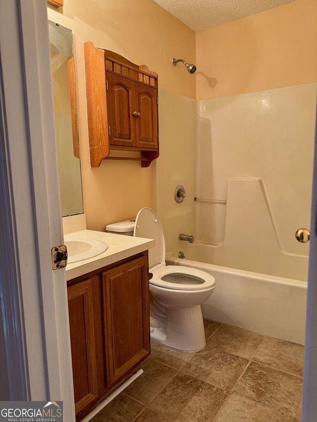 full bathroom featuring vanity, a textured ceiling, tub / shower combination, and toilet