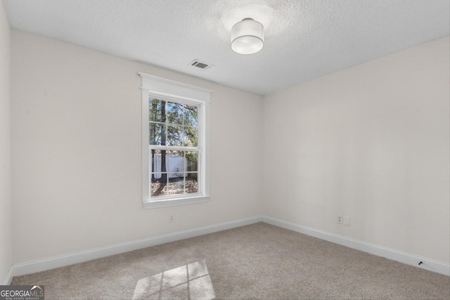 empty room featuring a textured ceiling and carpet flooring