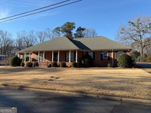 ranch-style house with a front lawn and a porch