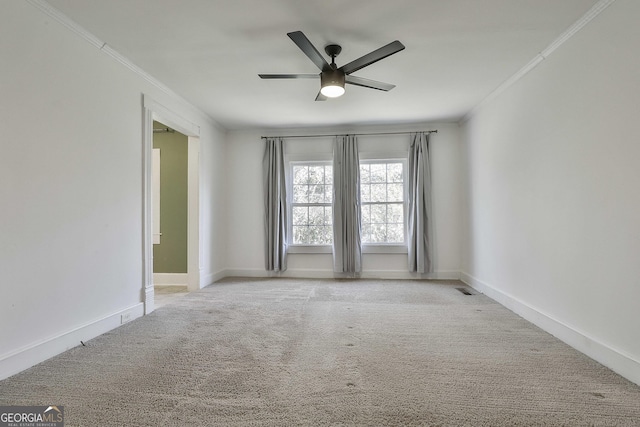 unfurnished room featuring ceiling fan, light colored carpet, and crown molding