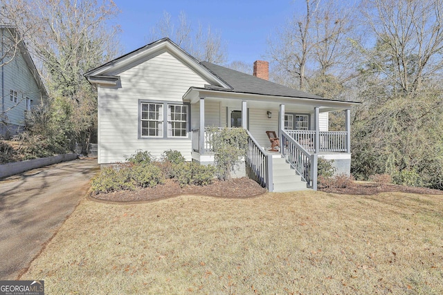 view of front of house with a front yard and a porch