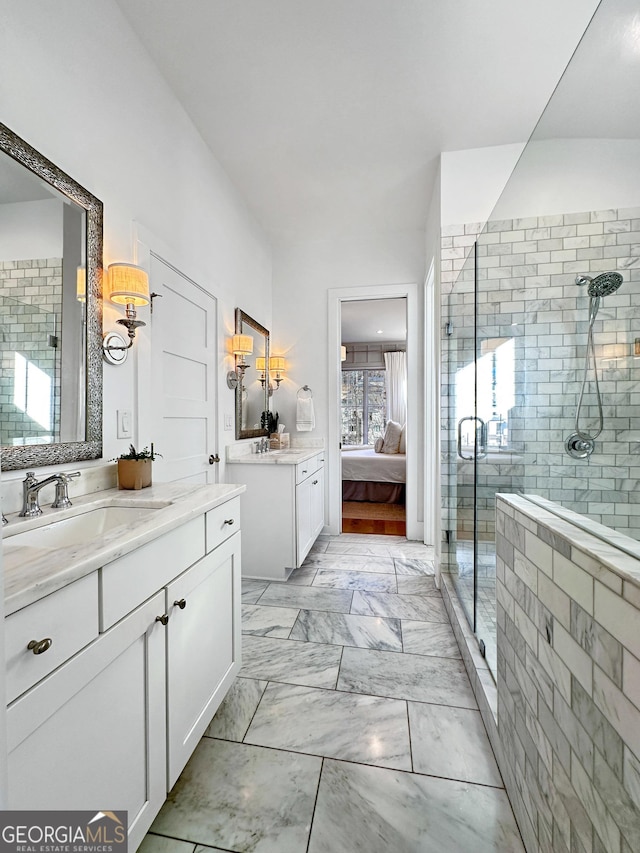 bathroom featuring a shower with door and vanity