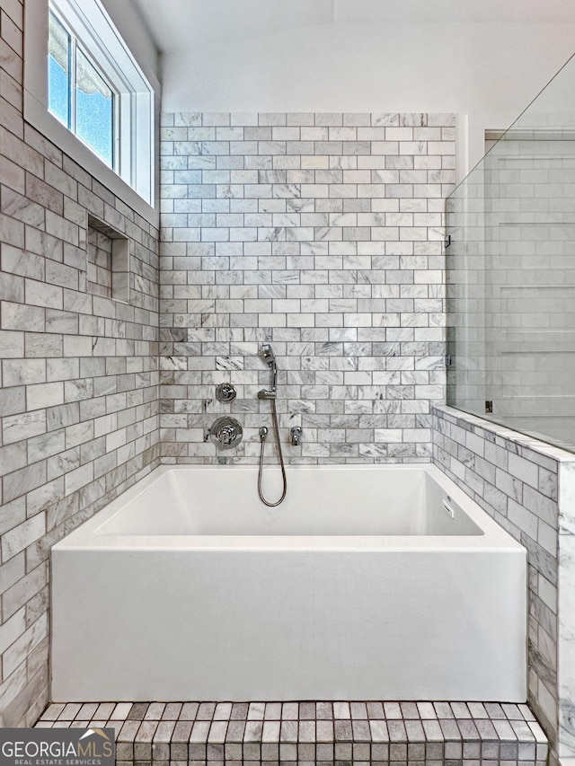 bathroom with tile walls and a bathing tub