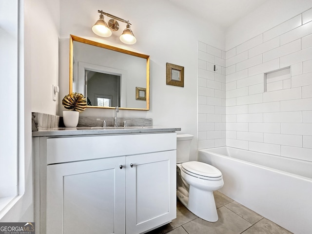 full bathroom featuring tiled shower / bath combo, vanity, toilet, and tile patterned flooring