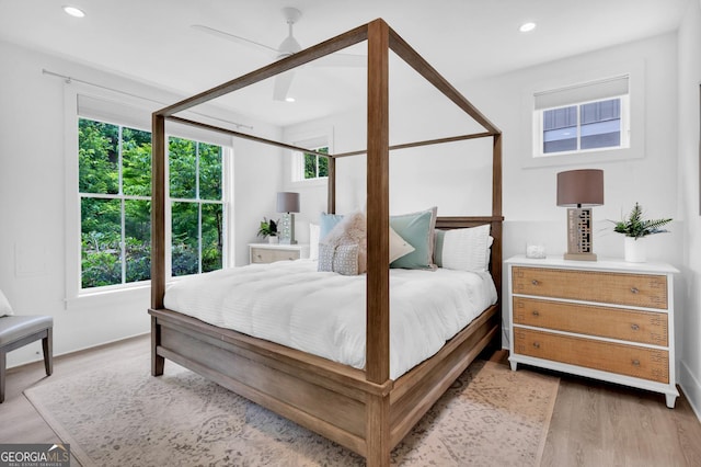 bedroom featuring ceiling fan, multiple windows, and hardwood / wood-style flooring