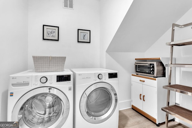 washroom with separate washer and dryer and light hardwood / wood-style floors