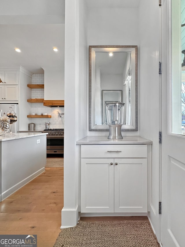 bathroom featuring wood-type flooring and tasteful backsplash