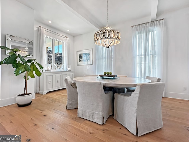 dining space with light wood-type flooring, a notable chandelier, and beamed ceiling