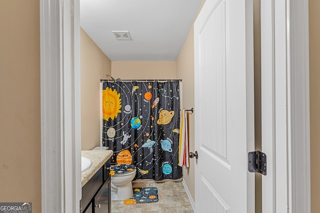 bathroom featuring toilet, vanity, and walk in shower