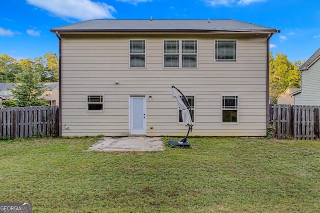 rear view of property featuring a lawn and a patio area