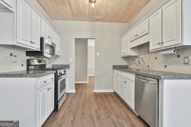 kitchen featuring stainless steel appliances, wood ceiling, white cabinetry, and sink