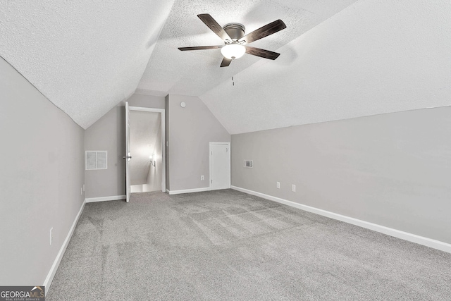 additional living space featuring a textured ceiling, ceiling fan, lofted ceiling, and light carpet