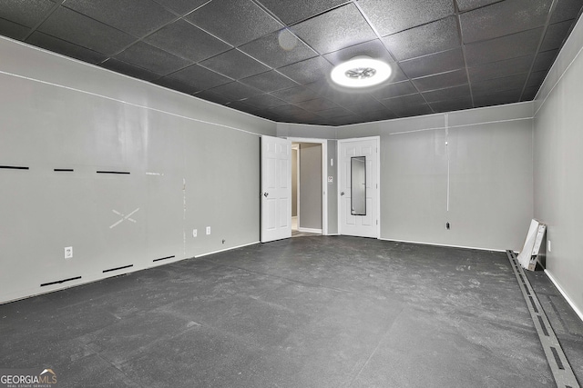 empty room featuring a paneled ceiling and electric panel