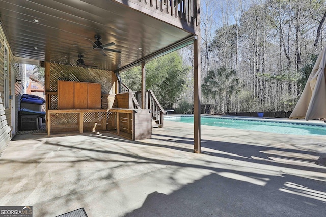 view of patio with ceiling fan and a balcony