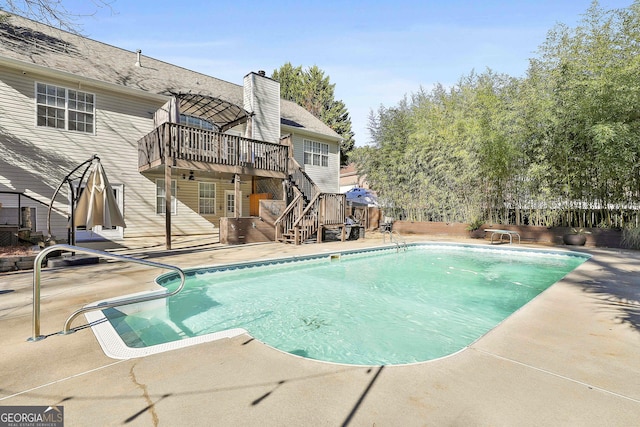 view of swimming pool featuring a diving board and a patio area