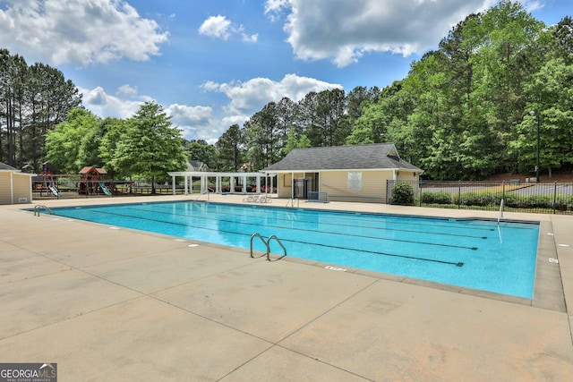 view of pool featuring a playground and a patio