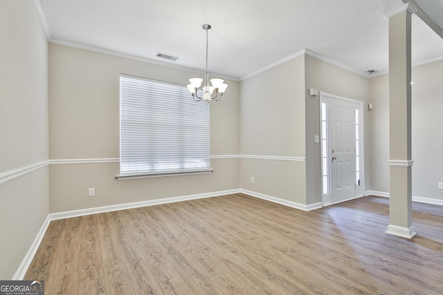 unfurnished room with a textured ceiling, crown molding, a chandelier, and light hardwood / wood-style floors