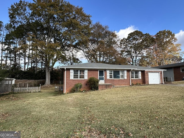 ranch-style home with an attached garage, brick siding, fence, and a front yard