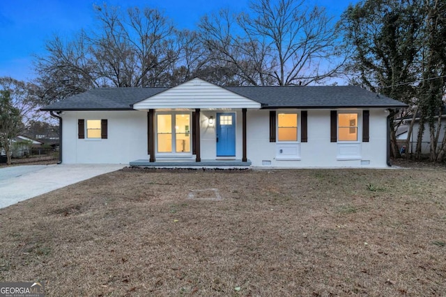 ranch-style home featuring a front lawn and covered porch