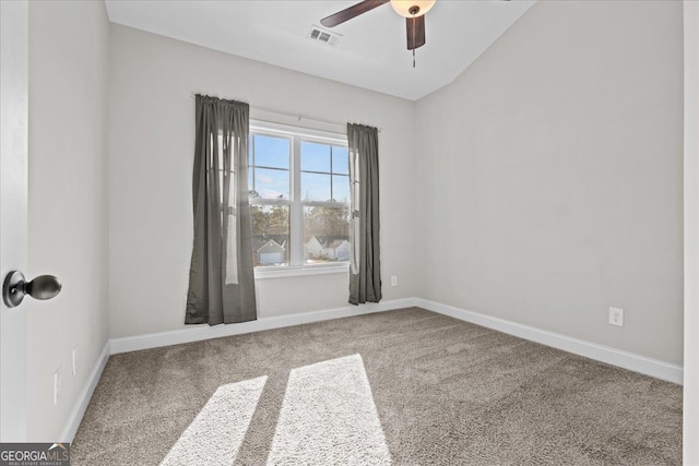 carpeted spare room featuring a ceiling fan, visible vents, and baseboards