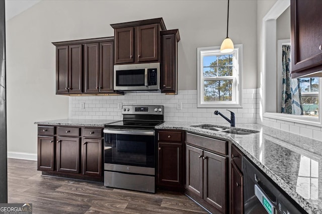 kitchen with dark wood-style floors, appliances with stainless steel finishes, a sink, and pendant lighting