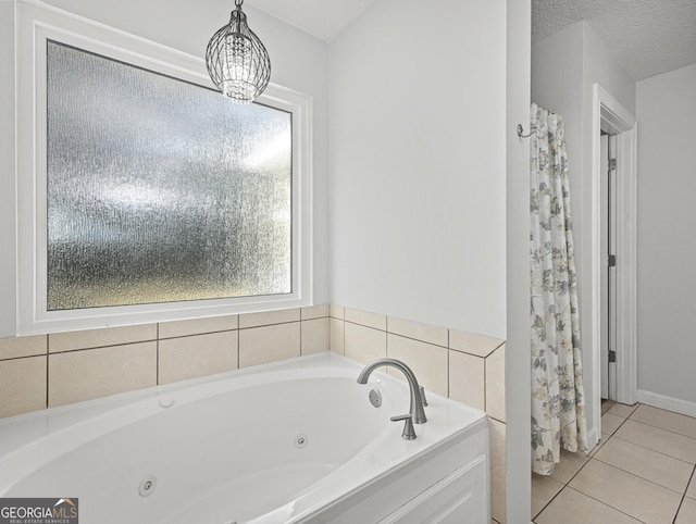 bathroom with a tub to relax in, a chandelier, tile patterned flooring, and a textured ceiling