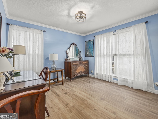 living area featuring light hardwood / wood-style floors, a textured ceiling, and crown molding