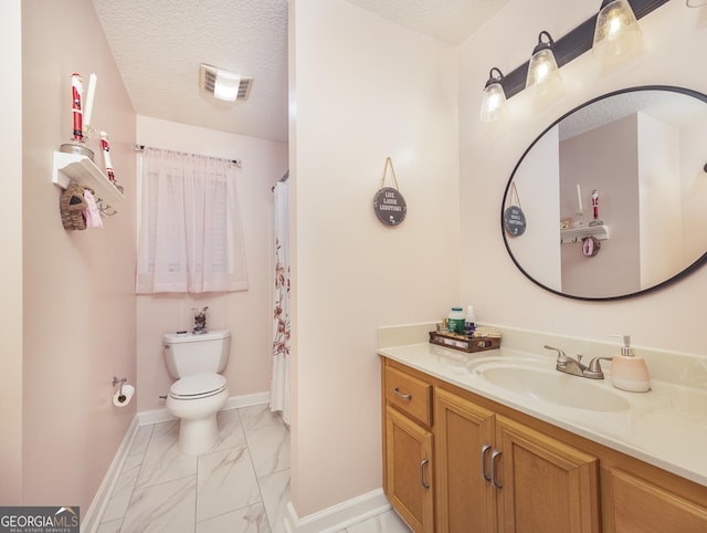 bathroom featuring a textured ceiling, toilet, and vanity