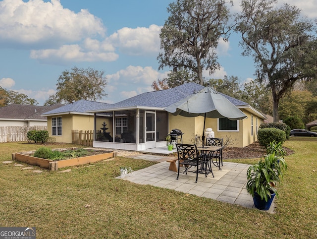 rear view of property featuring a sunroom, a yard, and a patio