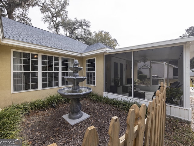 back of house featuring ceiling fan and a sunroom