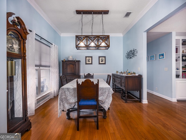 dining space featuring a textured ceiling, dark hardwood / wood-style flooring, and crown molding