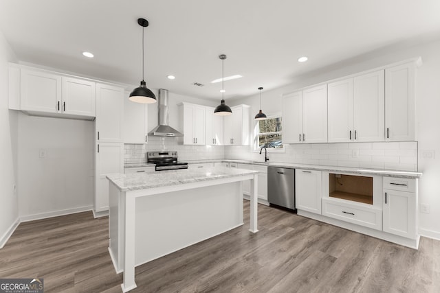 kitchen with white cabinetry, stainless steel appliances, wall chimney exhaust hood, and light wood-style floors