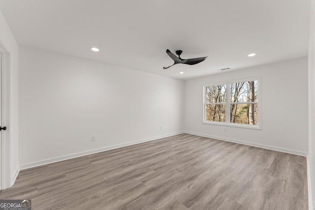 empty room with recessed lighting, baseboards, wood finished floors, and a ceiling fan