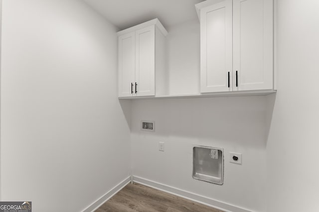 clothes washing area with wood finished floors, baseboards, hookup for an electric dryer, cabinet space, and washer hookup