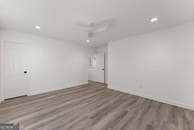 spare room featuring wood finished floors, recessed lighting, a ceiling fan, and baseboards