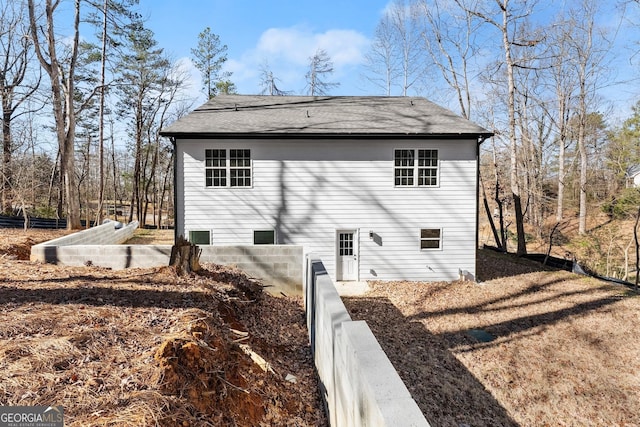 back of property with a shingled roof