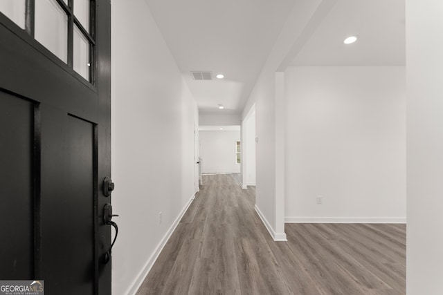 hallway featuring recessed lighting, visible vents, baseboards, and wood finished floors