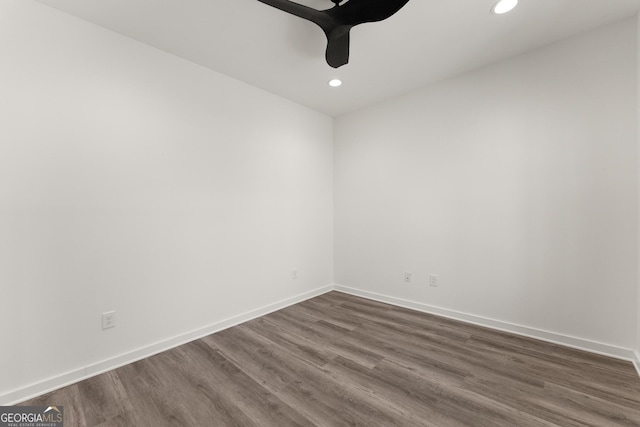 spare room with dark wood-type flooring, recessed lighting, a ceiling fan, and baseboards