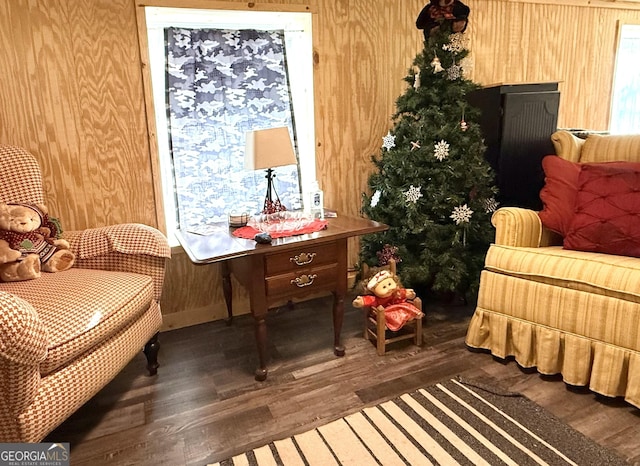 sitting room featuring dark wood-type flooring and wood walls