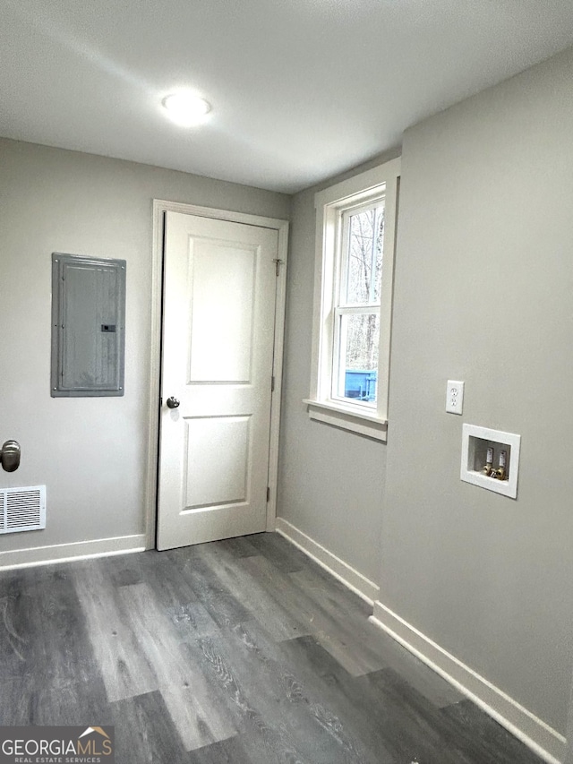 clothes washing area featuring electric panel, dark hardwood / wood-style flooring, and hookup for a washing machine