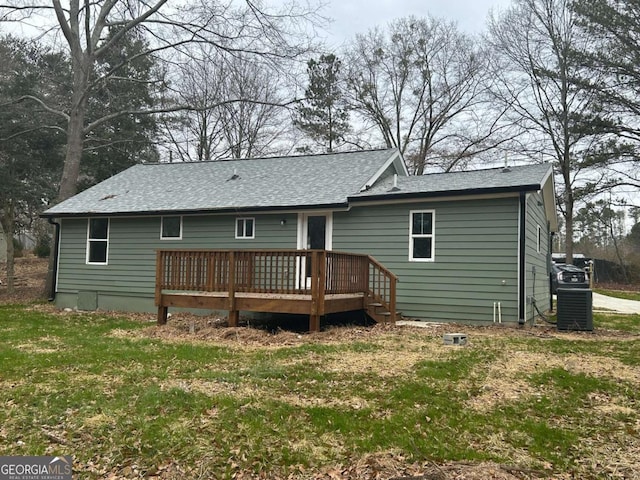 back of house with central AC unit, a wooden deck, and a lawn