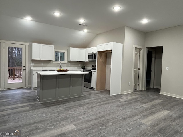 kitchen featuring white cabinetry, dark wood-type flooring, stainless steel appliances, and a kitchen island