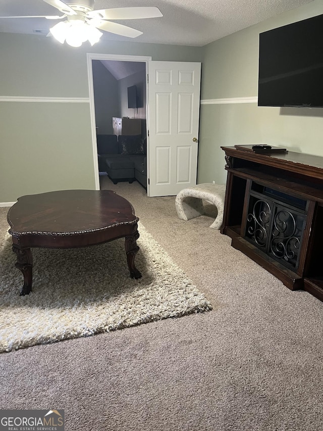 interior space with ceiling fan, a textured ceiling, and carpet flooring