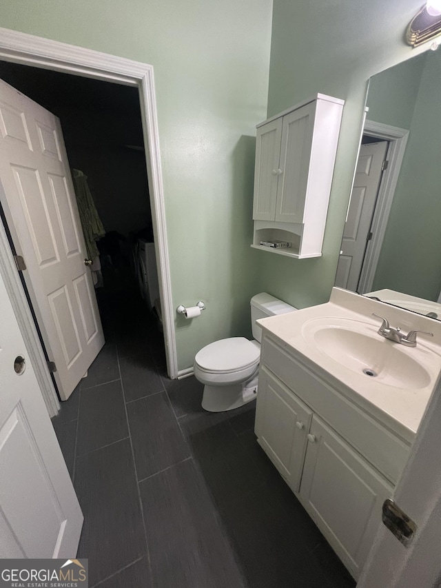 bathroom featuring toilet, vanity, and tile patterned floors