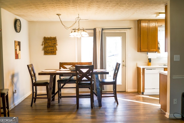 dining area with a textured ceiling, dark hardwood / wood-style floors, and an inviting chandelier