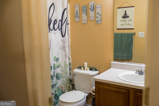 bathroom with toilet, vanity, and a shower with curtain