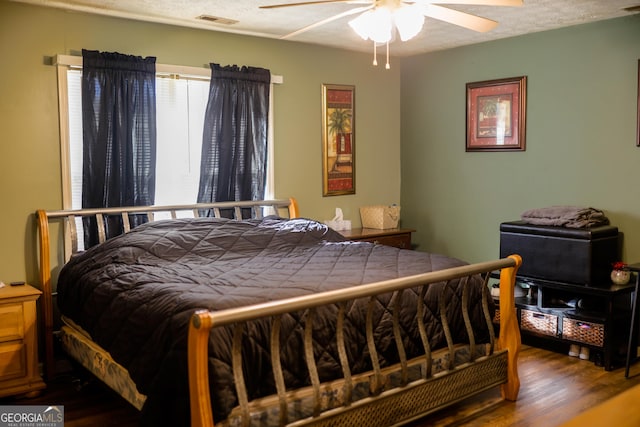 bedroom featuring ceiling fan, a textured ceiling, and hardwood / wood-style floors